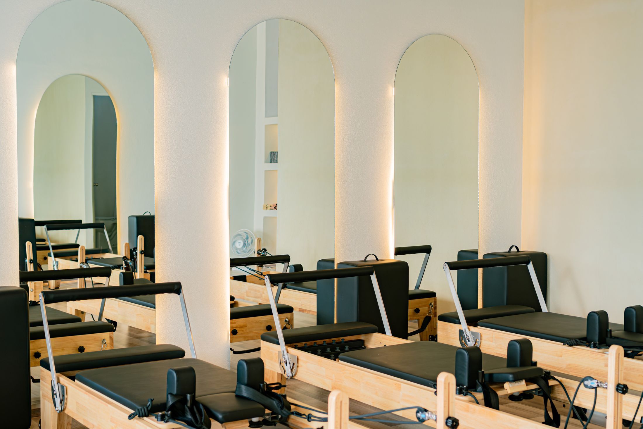 A bright pilates studio with wooden reformer machines